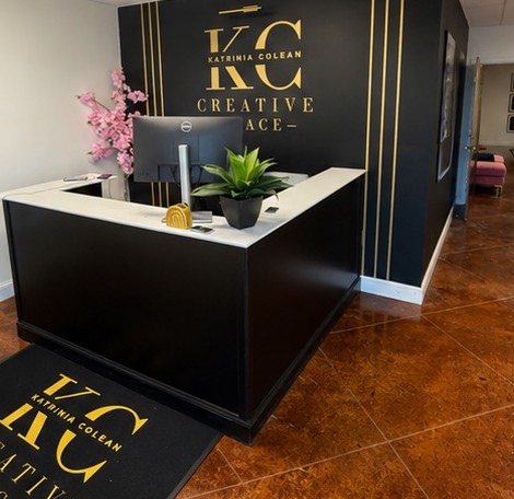 Reception desk with signature KC Katrinia Colean gold logo on the wall